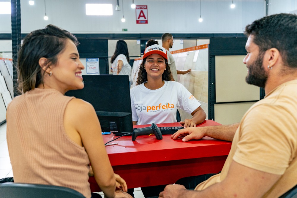 Casal sendo atendido por uma vendedora em uma loja de materiais de construção