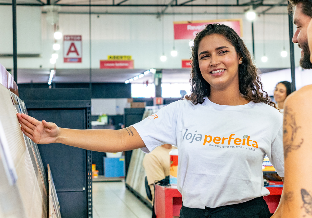 Vendedora mostrando revestimentos em loja de materiais de construção